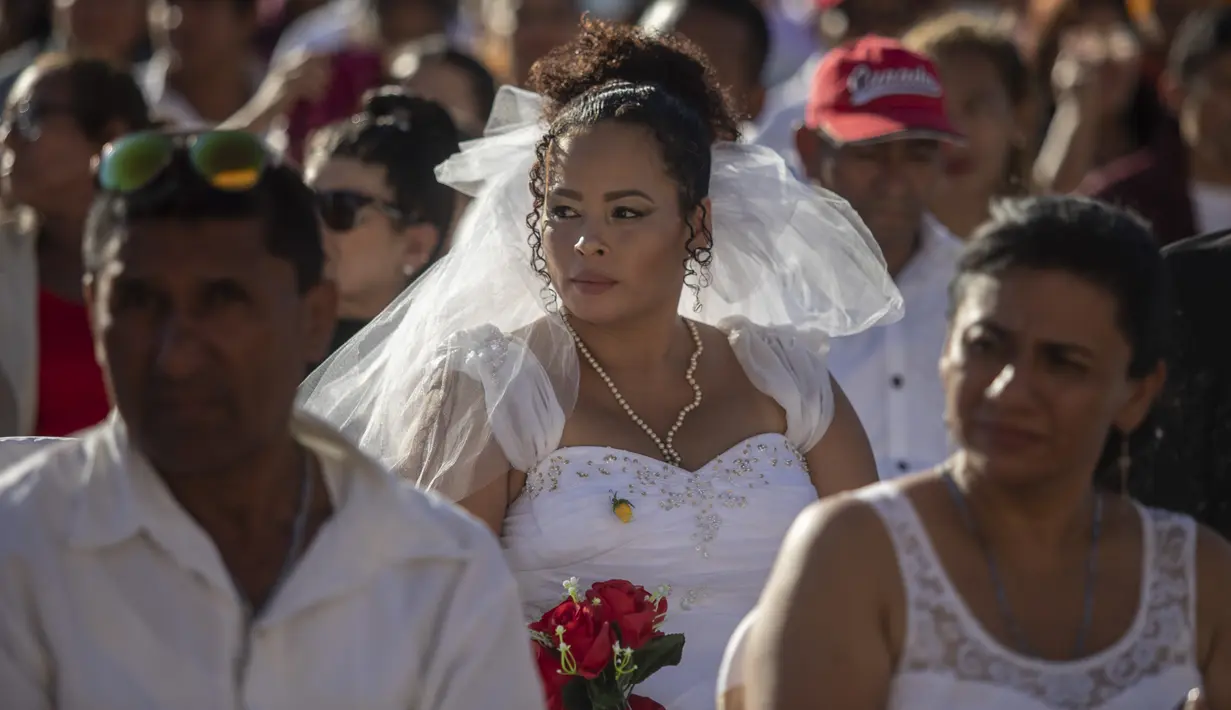 Seorang mempelai wanita terlihat menghadiri pernikahan massal di Managua, Nikaragua, Selasa  (14/2/2023). Acara tersebut diselenggarakan oleh stasiun radio Sandinista "La Nueva Radio Ya", dan sekitar 263 pasangan menikah di Lapangan Revolusi. (AP Photo/Inti Ocon)