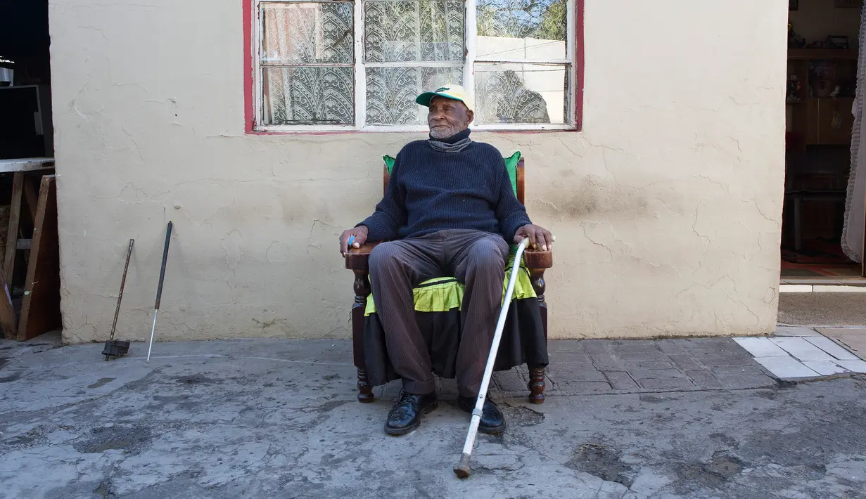 Fredie Blom berpose untuk potret sambil merayakan ulang tahun yang ke 116 di rumahnya di Delft, dekat Cape Town, 8 Mei 2020. Menurut 'Oupa' (kakek) Fredie dan kartu identitasnya, ia lahir pada tahun 1904 yang menjadikannya salah satu pria tertua di dunia. (RODGER BOSCH/AFP)
