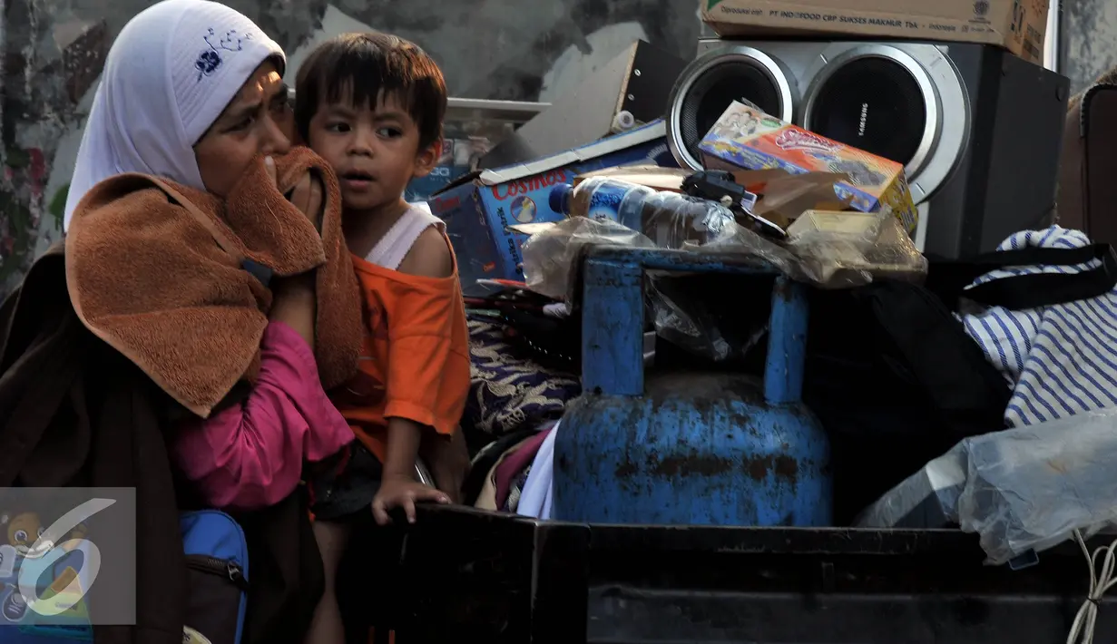 Seorang ibu menyaksikan rumahnya terbakar saat terjadinya kebakaran yang melanda rumah hunian semi permanen di bantaran sungai anak kali Ciliwung, Jakarta, Rabu (2/9/2015). Penyebab kebakaran tersebut belum di ketahui. (Liputan6.com/Johan Tallo)