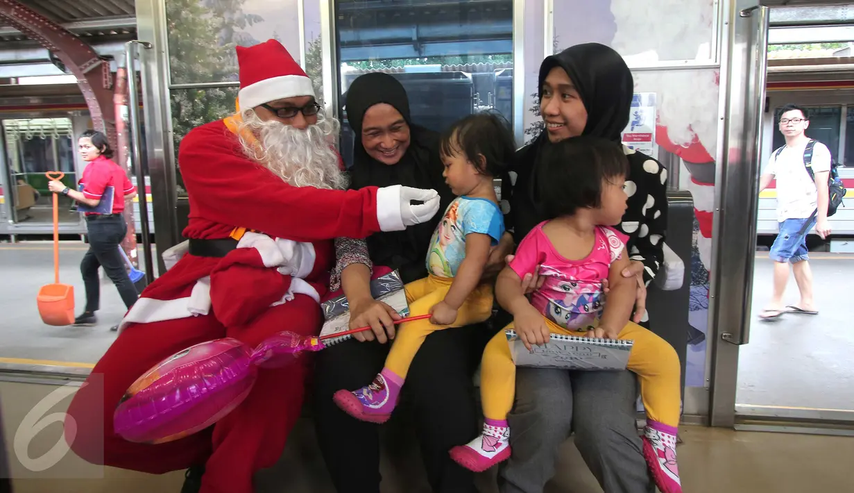 Sinterklas bercengkrama dengan para penumpang KRL di Jakarta, Jumat (25/12/2015). Keberadaan Sinterklas ini merupakan bentuk pelayanan KCJ dalam memperingati hari Natal. (Liputan6.com/Angga Yuniar)