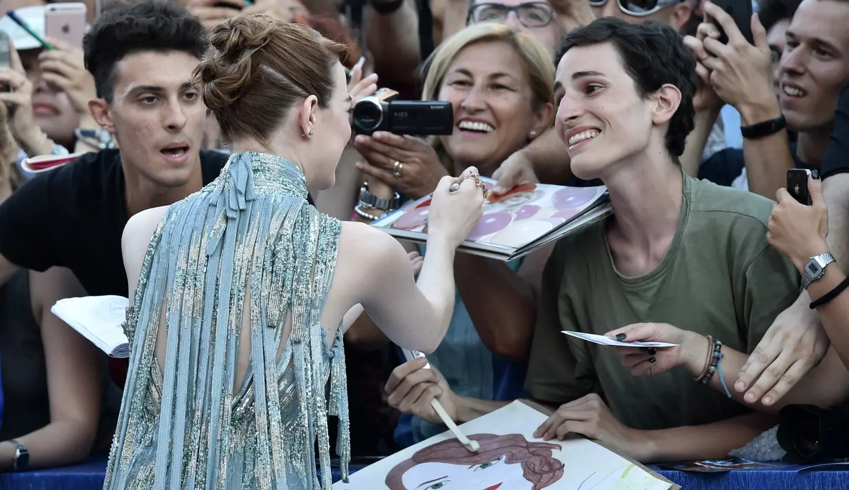 Aktris Emma Stone menyapa para fan saat tiba menghadiri pembukaan Festival Film Venice ke-73 di Italia, (31/8). Film La La Land menjadi pembuka festival ini. (AFP Photo/TIZIANA FABI)