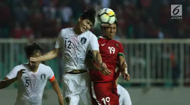 Gelandang Indonesia U-23, Hanif Abdurrauf Sjahbandi (kanan) berebut bola atas dengan pemain Korea Selatan U-23, Lee Sangmin pada laga persahabatan di Stadion Pakansari, Kab Bogor, Sabtu (23/6). Indonesia U-23 kalah 1-2. (Liputan6.com/Helmi Fithriansyah)