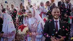Pasangan Palestina berpartisipasi dalam upacara pernikahan massal di Kota Hamad, Khan Younis, Jalur Gaza, Selasa 2 Desember 2025. 54 pasangan muda Palestina di Gaza melangsungkan pernikahan massal pada Selasa (2/12/2025). (AP Photo/Abdel Kareem Hana)