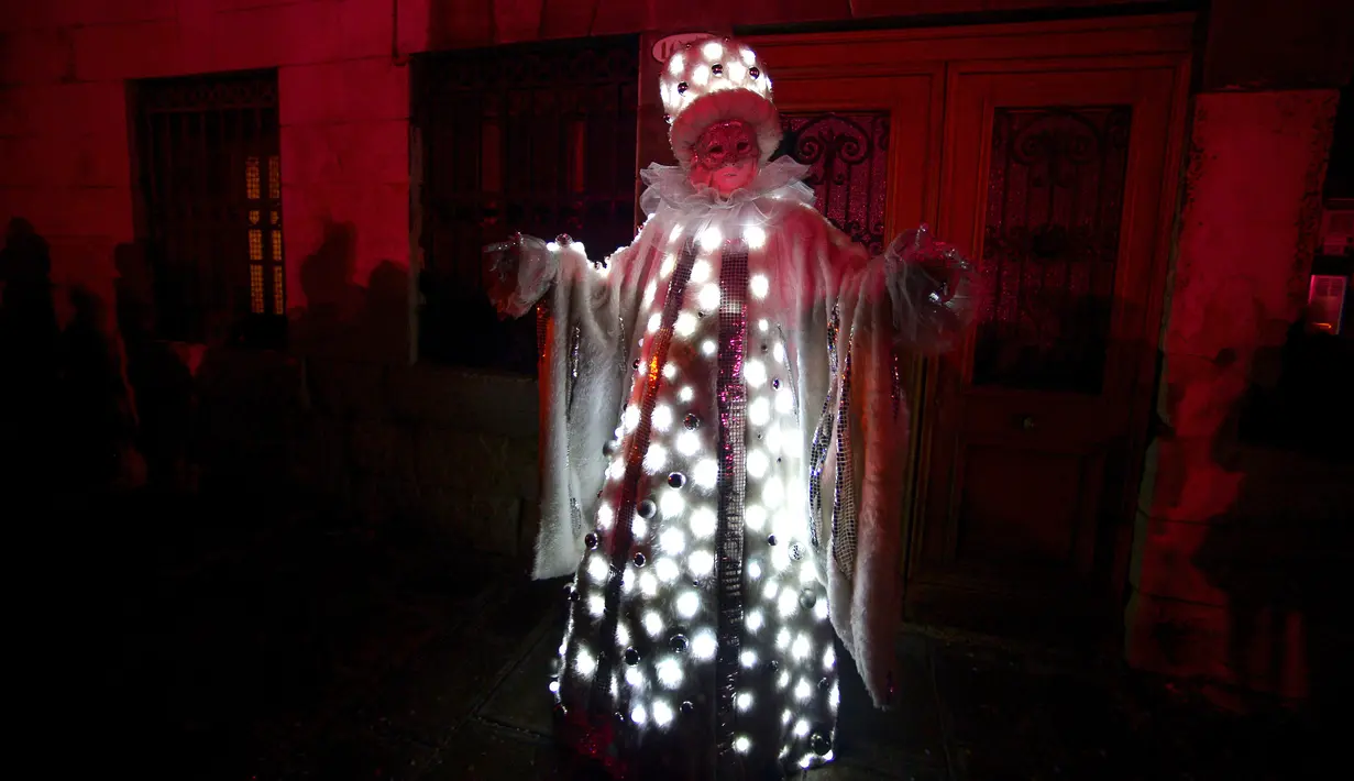 Seorang peserta berpakaian topeng dan kostum unik ambil bagian dalam upacara pembukaan Karnaval Venesia di Italia, Sabtu (27/1). Karnaval akan diadakan dari tanggal 27 Februari sampai 13 Februari. (FILIPPO MONTEFORTE/AFP)