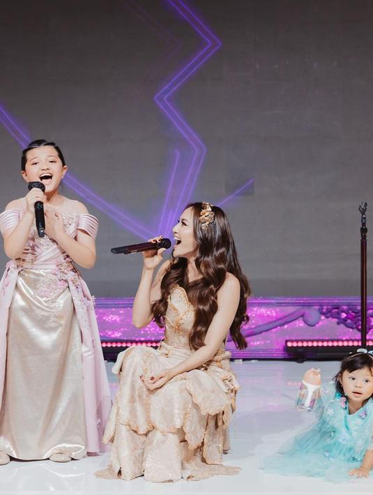 Tidak hanya tampil sendiri, Mahalini sempat berduet dengan Arsy Hermansyah. Dalam momen ini, terlihat perempuan asal Bali itu juga bak momong putri Aurel, Ameena, yang ikut naik ke panggung. Di salah satu foto unggahan, penyanyi yang disapa Lini itu tampak gemas dengan Ameena. (Liputan6.com/IG/@mahaliniraharja)