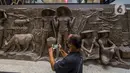 Pengunjung melihat relief peninggalan Bung Karno di pusat perbelanjaan Sarinah di Jakarta, Senin (21/3/2022). Relief bersejarah peninggalan Presiden pertama RI, IR Soekarno tersebut ditemukan di Basement Gedung Sarinah saat pemugaran pada awal Januari 2021 lalu. (Liputan6.com/Faizal Fanani)