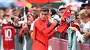 Pemain Bayern Munchen, Philippe Coutinho, menyapa suporter saat latihan perdananya di Munchen, Selasa (20/8). Bintang Brasil ini didatangkan dari Barcelona. (AFP/Christof Stache)