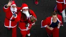 Peserta berkostum Sinterklas melambaikan tangan saat mengikuti Santa Claus Run di Madrid, Spanyol, Minggu (9/12). Ribuan orang berjalan dan berlari dalam perlombaan Santa tahunan melintasi jalan-jalan ibu kota Spanyol. (Gabriel BOUYS / AFP)