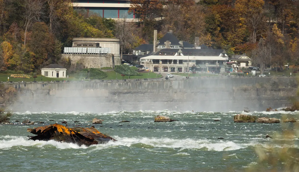 Sebuah kapal yang karam di atas Horseshoe Falls dari Air Terjun Niagara setelah bergeser di Ontario, Kanada, Senin (4/11/2019). Dikenal sebagai 'Iron Scow', kapal tersebut merupakan ikon Air Terjun Niagara setelah terjebak di batu selama 101 tahun. (Tara Walton/The Canadian Press via AP)