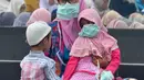 Umat muslim mengenakan masker saat mendengarkan ceramah usai melaksanakan salat Idul Adha di halaman Masjid Raya Annur, Kota Pekanbaru, Riau, Minggu (11/8/2019). Kabut asap imbas kebakaran hutan dan lahan (karhutla) menyelimuti pelaksanaan salat Idul Adha 2019 di Pekanbaru. (Wahyudi/AFP)