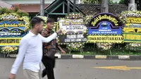 Pelayat melintasi karangan bunga duka cita untuk mendiang Eka Tjipta Widjaja di depan Rumah Duka Sentosa RSPAD Gatot Soebroto, Jakarta, Minggu (27/1). Pendiri Sinar Mas Group tersebut meninggal dunia pada 26 Januari 2019. (Merdeka.com/Iqbal Nugroho)