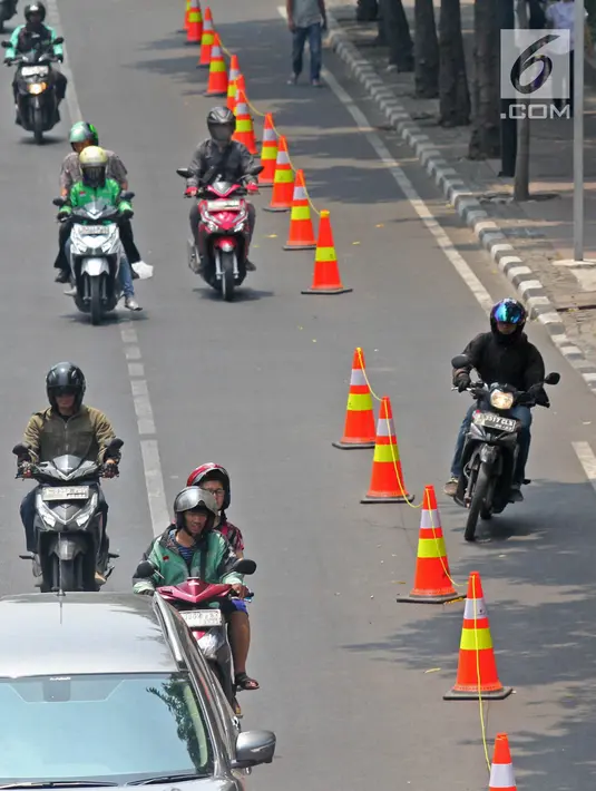 Pengendara sepeda motor melintasi jalur sepeda di Jalan MH Thamrin, Jakarta, Selasa (24/9/2019). Jalur sepeda tersebut sedang dalam masa uji coba mulai 20 September hingga 19 November 2019. (Liputan6.com/Herman Zakharia)