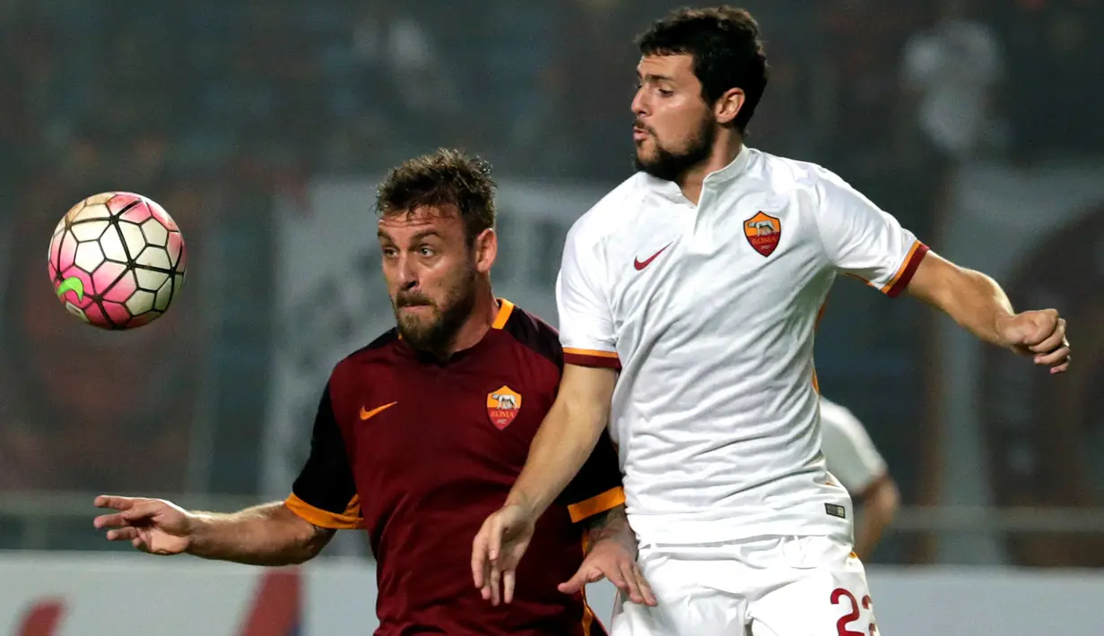 Danielle De Rossi (kiri) berebut bola dengan Mattia Destro. (EPA/Mast Irham)
