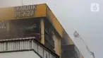 Personel pemadam kebakaran terus melakukan penyemprotan untuk pendinginan setelah terjadi kebakaran di Glodok Plaza, Jakarta, Kamis (16/1/2025). (Liputan6.com/Angga Yuniar)