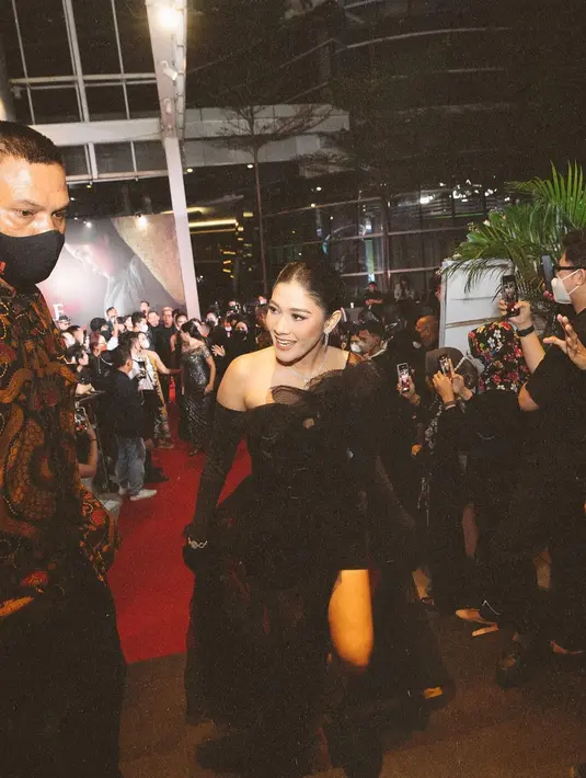 Salah satu pose memperlihatkan jati diri Naysilla Mirdad sebagai aktris papan atas. Ia melaju ke karpet merah, sementara sejumlah tamu undangan mengabadikan momen itu dengan kamera ponsel. Seorang pria berkemeja batik lengan panjang, tampak mengawal dan mengawasi langkah Naysilla Mirdad di karpet merah. Suasana seperti ini sekitar dua tahun tak terjadi akibat wabah. (Foto: Dok. Instagram @naymirdad)