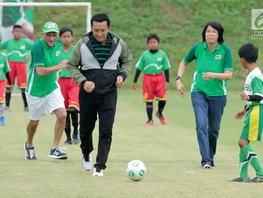 Menpora, Imam Nahrawi didampingi Dharnesh Gordhon dan Prawitya Soemadijo menggiring bola pada acara kompetisi sepak bola U-12 antar Sekolah Dasar, MILO Football Championship 2018, di Senayan, Jakarta, Sabtu (24/3).  (Liputan6.com/Pool/Rizky)