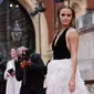 Aktris Inggris Emma Watson berpose di karpet merah saat tiba di BAFTA British Academy Film Awards di Royal Albert Hall, di London (13/3/2022). Emma Watson melengkapi ansambel sensasionalnya dengan sepasang anting rumbai perak mewah dan serangkaian cincin perak. (AFP/Tolga Akmen)
