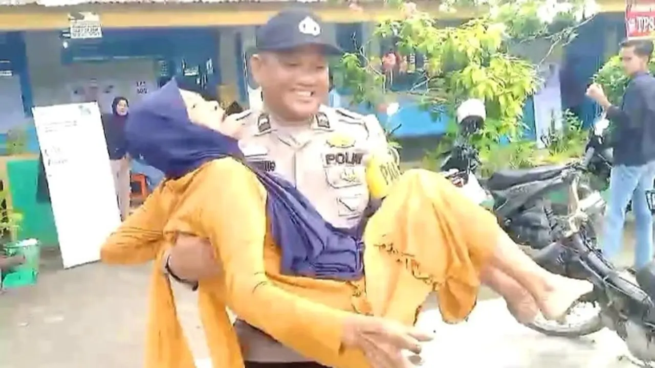 Tangkapan layar polisi gendong nenek untuk menyalurkan hak politiknya di tempat pemungutan suara pada Pemilu 2024.