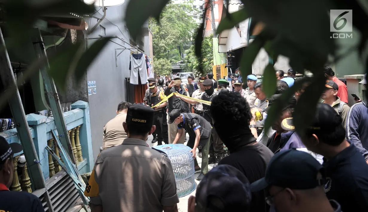 Petugas kepolisian saat menggeledah kediaman orang tua terduga teroris di Jalan Belibis V, Semper Barat, Cilincing, Jakarta, Senin (23/9/2019). Selain rumah tersangka, polisi juga menggeledah kediaman orang tua terduga teroris yang tidak jauh dari TKP. (merdeka.com/Iqbal S. Nugroho)