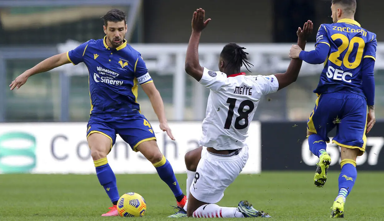 Pemain AC Milan, Soualiho Meite, menghadang pemain Verona, Miguel Veloso, pada laga Liga Italia di Stadion Bentegodi, Minggu (7/3/2021). AC Milan menang dengan skor 2-0. (Spada/LaPresse via AP)