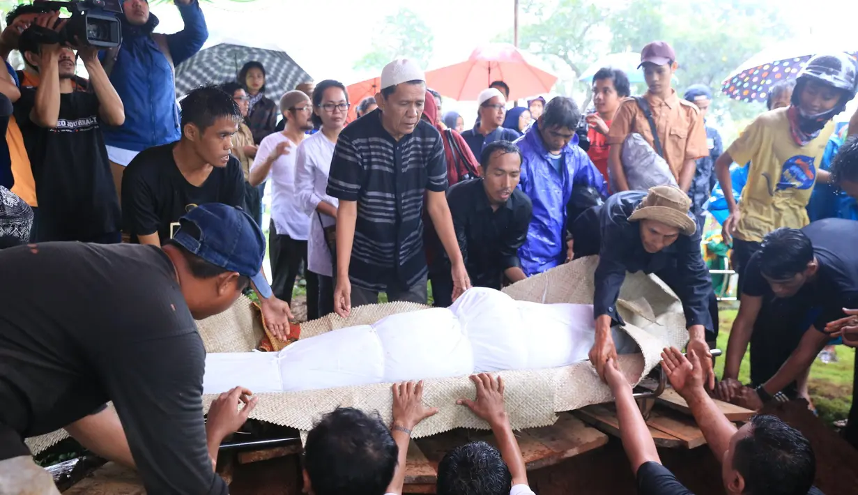 Air mata sang suami kembali pecah ketika jenazah dimasukkan ke liang lahat hendak di urug dengan tanah. Kepergian secara mendadak itulah mungkin yang membuat ia belum bisa menerima sepenuhnya. (Adrian Putra/Bintang.com)