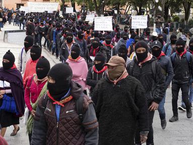 Anggota Tentara Pembebasan Nasional Zapatista (EZLN) berbaris selama protes terhadap kapitalisme dan invasi Rusia di Ukraina, di San Cristobal de las Casas, negara bagian Chiapas, Meksiko (13/3/2022). Zapatista menuntut penghentian perang dan berakhirnya kapitalisme. (AP Photo/Isabel Mateos)