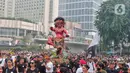 Umat Hindu mengarak ogoh-ogoh saat hari bebas berkendara di kawasan Bundaran HI, Jakarta, Minggu (12/3/2023). Pawai ogoh-ogoh tersebut diselenggarakan dalam rangka menyambut Perayaan Nyepi Tahun Baru Saka 1945/2023. (Liputan6.com/Angga Yuniar)