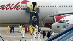 Sejumlah Warga Negara Indonesia (WNI) yang dievakuasi dari Wuhan, China keluar dari pesawat  Batik Air di bandara internasional Hang Nadim, Batam, Minggu (2/2/2020). Sebanyak 245 WNI di Wuhan akan dievakuasi ke Indonesia terkait merebaknya virus corona di kota tersebut. (AFP/Ricky Prakoso)