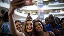 Miss Universe 2017 asal Afrika Selatan, Demi-Leigh Nel-Peters berswafoto dengan penggemarnya saat tiba di Bandara Internasional OR Tambo di Johannesburg (24/1). (AFP Photo/Gulshan Khan)