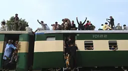 Warga Pakistan menaiki kereta api yang penuh sesak saat orang-orang melakukan perjalanan ke kampung halaman dan desa mereka untuk merayakan Idul Adha, atau "Hari Raya Kurban," di Lahore, Pakistan, Kamis (7/7/2022). Idul Adha, hari raya Islam terpenting, menandai kesediaan Nabi Ibrahim, Ibrahim untuk mengorbankan anaknya. (AFP/Arif Ali)