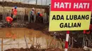 Sebuah papan peringatan terpasang di proyek sodetan Kali Ciliwung di kawasan Otista, Jakarta, Kamis (10/7/14). (Liputan6.com/Faizal Fanani)