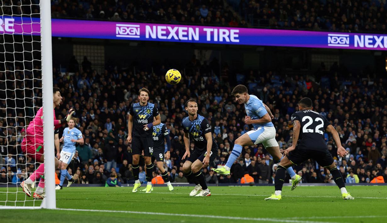 Pemain Manchester City, Julian Alvarez menyundul bola ke gawang Burnley pada laga Liga Inggris di Stadion Etihad, Kamis (1/2/2024). Dua dari tiga gol kemenangan City atas Burnley diborong oleh Julian Alvarez. (AFP/Darren Staples)