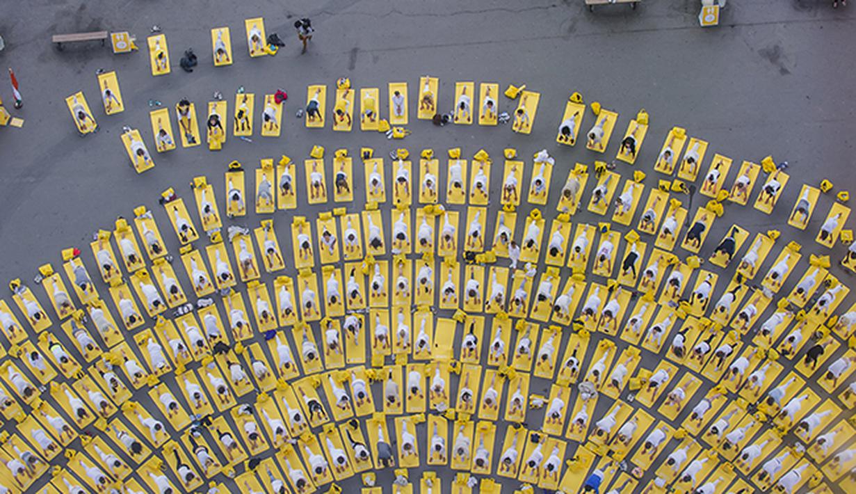 Peserta hari yoga sedunia di menara Eiffel, Paris, Prancis. (AP Photo/Kamil Zihnioglu)