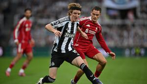 Gelandang Newcastle United, Anthony Gordon, berupaya lepas dari penjagaan pemain Liverpool, Florian Wirtz, pada lanjutan Liga Inggris 2025/2026 di St James' Park, Selasa (26/8/2025) dini hari WIB. (ANDY BUCHANAN / AFP)