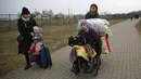 Pengungsi, sebagian besar wanita dan anak-anak, tiba di perbatasan di Medyka, Polandia, Sabtu (5/3/2022). Mereka melarikan diri dari invasi Rusia di Ukraina. (AP Photo/Visar Kryeziu)