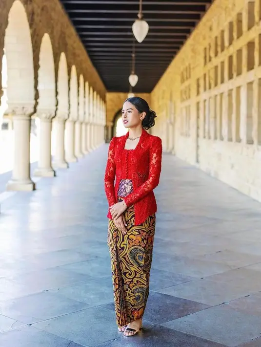 Saat seremoni kelulusan S2-nya di Stanford University, Maudy Ayunda tampil anggun berbalut kebaya kutubaru merah dengan stagen dan rok batik rancangan Didiet Maulana. (Instagram/maudyayunda).