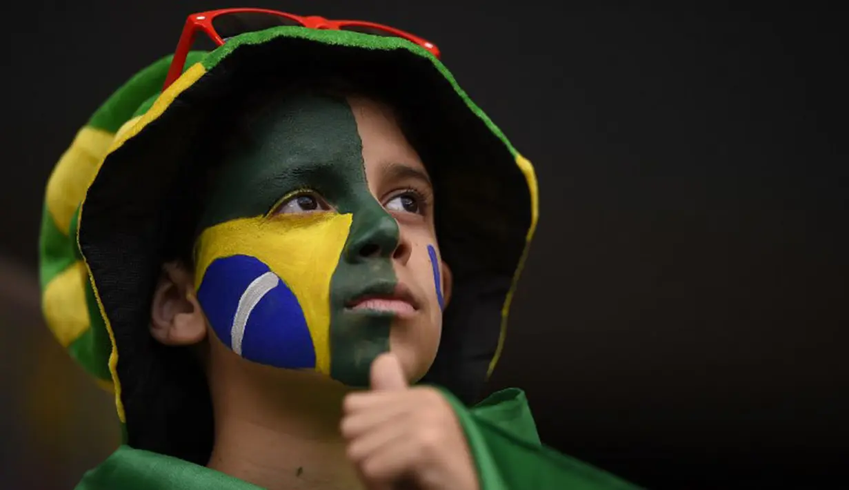 Suporter Brasil menatap hampa menyaksikan kekalahan tim Selecao dari Belanda 0-3 di laga perebutan tempat ketiga di Stadion Nasional Brasilia, (13/7/2014). (AFP PHOTO/Fabrice Coffrini)