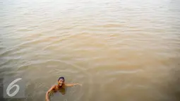 Seorang anak tampak ceria saat berenang di Sungai Kapuas, Pontianak, Kalimantan Barat, Sabtu (22/8/2015). Sungai Kapuas membentang sepanjang 1.143 kilometer. (Liputan6.com/Faizal Fanani)