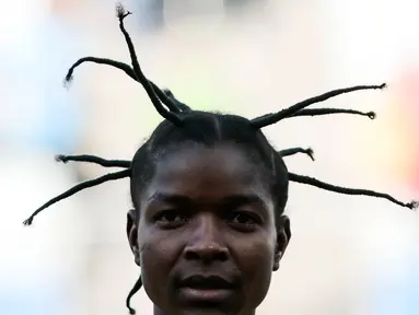 Pesepak bola wanita asal Zimbabwe, Marjory Nyaumw bersiap bertanding melawan Kanada di Grup F Olimpiade Rio 2016 di Korintus Arena, Brasil, (6/8). Atlet 29 tahun ini mengepang rambut gimbalnya ke atas yang jadi sorotan. (AFP PHOTO/Miguel SCHINCARIOL)