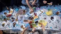 Orang-orang berbagi makanan dengan kerabat saat tiba waktu berbuka puasa di Taksim Square, Istanbul, Turki, Rabu (16/5). (Yasin AKGUL/AFP)