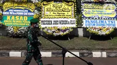 Prajurit TNI melintas di depan karangan bunga tanda duka cita atas meninggalnya mantan KSAD Jenderal TNI (Purn) Pramono Edhie Wibowo di kawasan Puri Cikeas, Kab Bogor, Jabar, Minggu (14/6/2020). Pramono Edhie Wibowo wafat di usia 65 tahun akibat serangan jantung. (Liputan6.com/Helmi Fithriansyah)