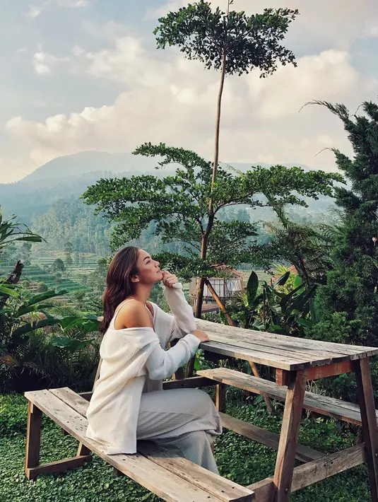 Tak sedikit netizen yang turut memberikan komentar pujian atas penampilan sederhana dari Angela Gilsha. Pada foto ini pun Angela terlihat sangat menikmati pemandangan hijau dan pegunungan yang ada. (Liputan6.com/IG/@angelagilsha)