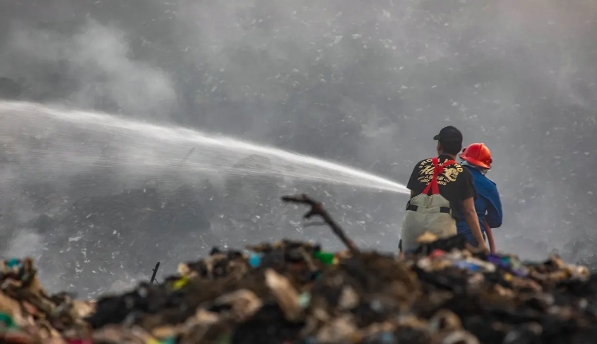 Petugas pemadam kebakaran berusaha memadamkan api di Tempat Pembuangan Akhir (TPA) Jatiwaringin, Kabupaten Tangerang, Banten, Jumat (03/07/2026). (Merdeka.com/ Arie Basuki)