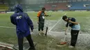 Para petugas berusaha menguras air yang menggenangi lapangan di Stadion Patriot, Bekasi, Senin (13/11/2017). Drainase yang buruk menyebabkan lapangan terendam air. (Bola.com/M Iqbal Ichsan)