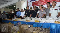 Petugas Bea dan Cukai dan Porles Metro Bandara memperlihatkan barang bukti Narkoba yang disita dari para tersangka di Bandara Soetta, Tangerang, Kamis (27/8/2015).  Petugas berhasil menyita sekitar 94 kg dan 12.189 ekstasi. (Liputan6.com/Gempur M Surya)