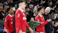 Pelatih Manchester United, Erik ten Hag, berbincang dengan Jadon Sancho saat melawan Nottingham Forest pada leg kedua babak semifinal Carabao Cup, di Stadion Old Trafford, Jumat (2/2/2023). Jadon Sancho kembali bermain untuk Manchester United setelah cukup lama hilang. (AFP/Paul Ellis)