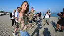 Model Afrika Selatan Candice Swanepoel menyapa awak media sebelum sesi pemotretan di pantai Lido menjelang pembukaan Festival Film Venesia ke-76 di Venice Lido, Italia (27/8/2019). (AFP Photo/Vincenzo Pinto)