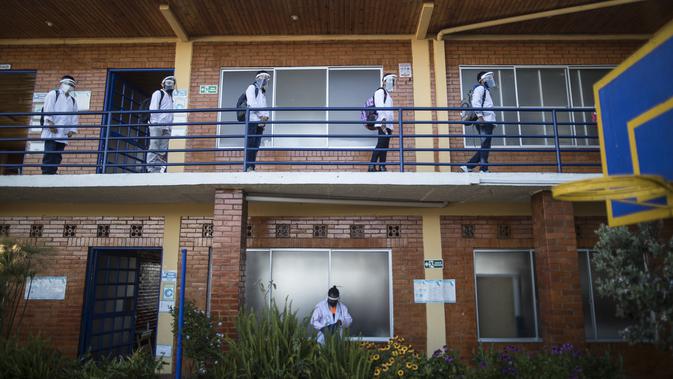 Siswa dengan menjaga jarak memasuki ruang kelas pada hari pertama kembali ke kelas tatap muka sejak Maret 2020 di Liceo Lunita, sebuah sekolah swasta di Chia, pinggiran Bogota, Kolombia, Jumat (5/2/2021). Sejauh ini Kolombia melaporkan lebih dari 2,13 juta kasus Covid-19. (AP Photo/Ivan Valencia)