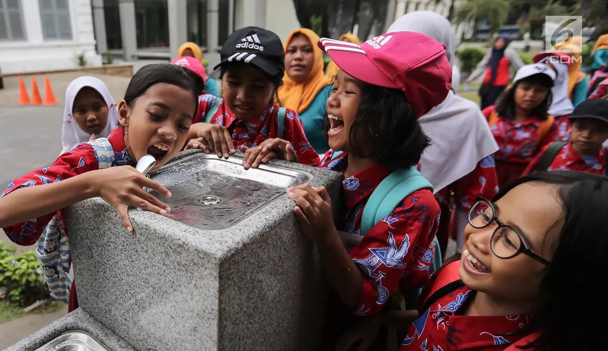 Anak-anak sekolah berebut air minum di fasilitas air siap minum (Drinking Fountain) di Museum Nasional, Jakarta, Kamis (8/11). Pembangunan drinking fountain ini untuk menyediakan air siap minum yang higienis bagi masyarakat. (Liputan6.com/Fery Pradolo)