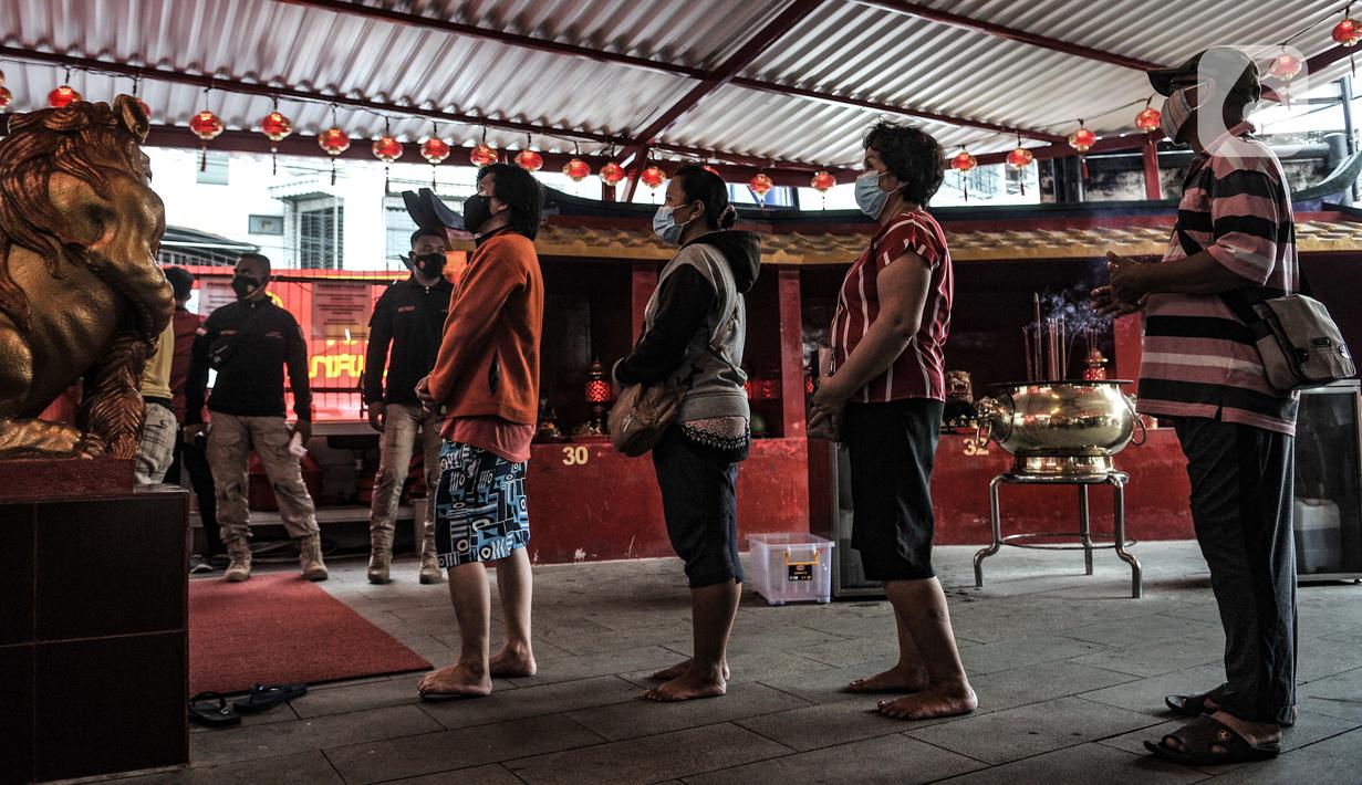 Warga keturunan Tionghoa antre untuk melaksanakan sembahyang malam Tahun Baru Imlek 2572 di klenteng kawasan Petak Sembilan, Glodok, Jakarta, Kamis (11/2/2021). Pihak klenteng membatasi jumlah umat yang ingin sembahyang maksimal 50 persen. (merdeka.com/Iqbal S. Nugroho)